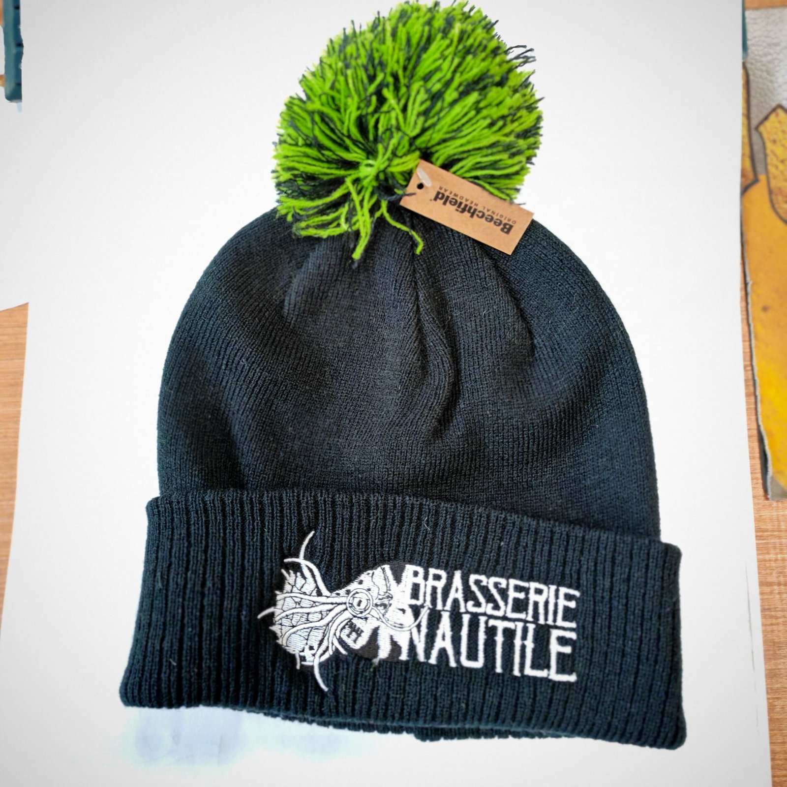 235405b7-4ef5-49b9-831b-c9a49ae31829.jpg Bonnet Noir / Ponpon Noir et vert – Brasserie Nautile – Image 1